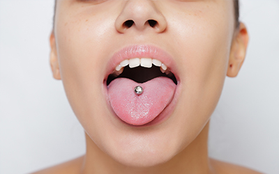 A woman sticking her pierced tongue out