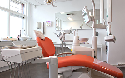 Empty orange dental chair and equipment