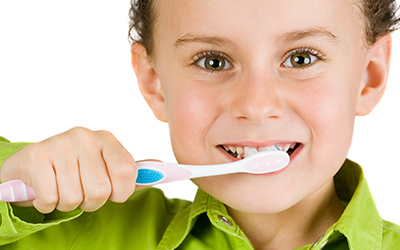 A young boy brushing their teeth