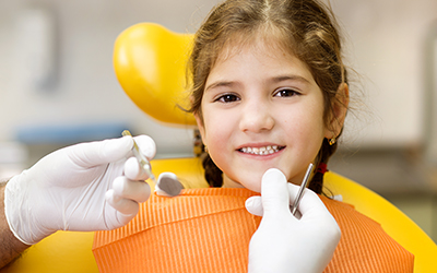 A young girl smiling in a dental chair